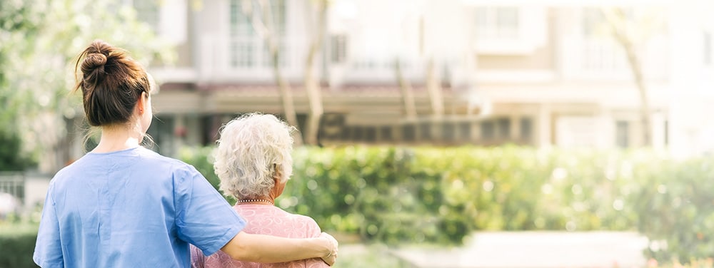 caregiver walking with elderly woman outdoor